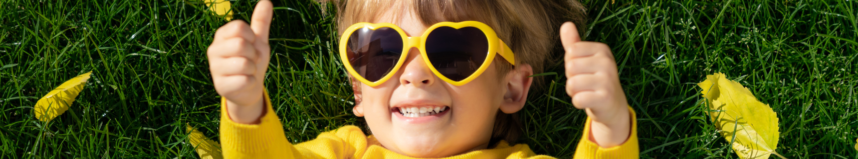 little girl in yellow sunglasses giving thumbs up