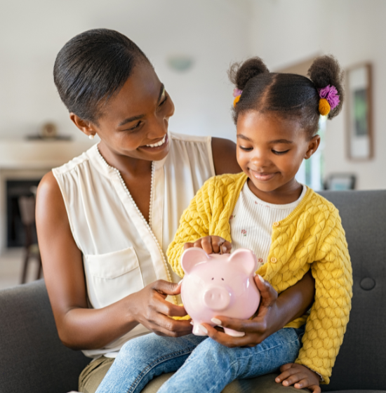 mom and daughter holding piggy bank