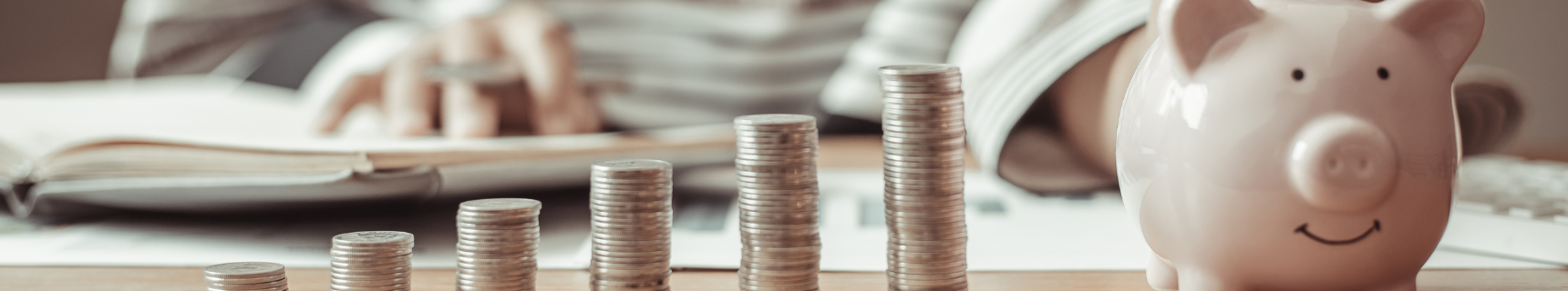 coins stacked next to a piggy bank